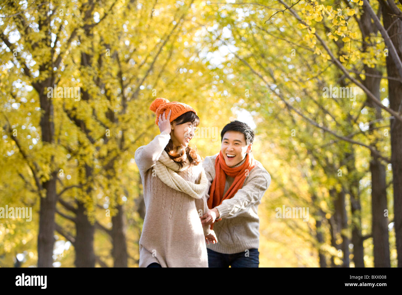 Young Couple Playing in a Park in Autumn Stock Photo - Alamy