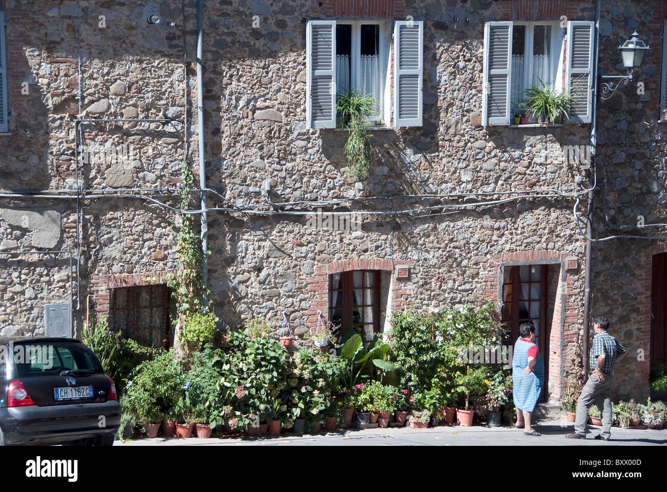 Man and a woman, chatting in the sun in the Umbrian town of Ficulle, Italy Stock Photo