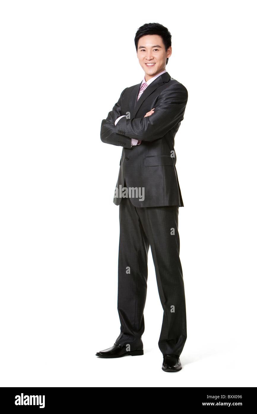 Full length of businessman smiling with arms crossed Stock Photo - Alamy