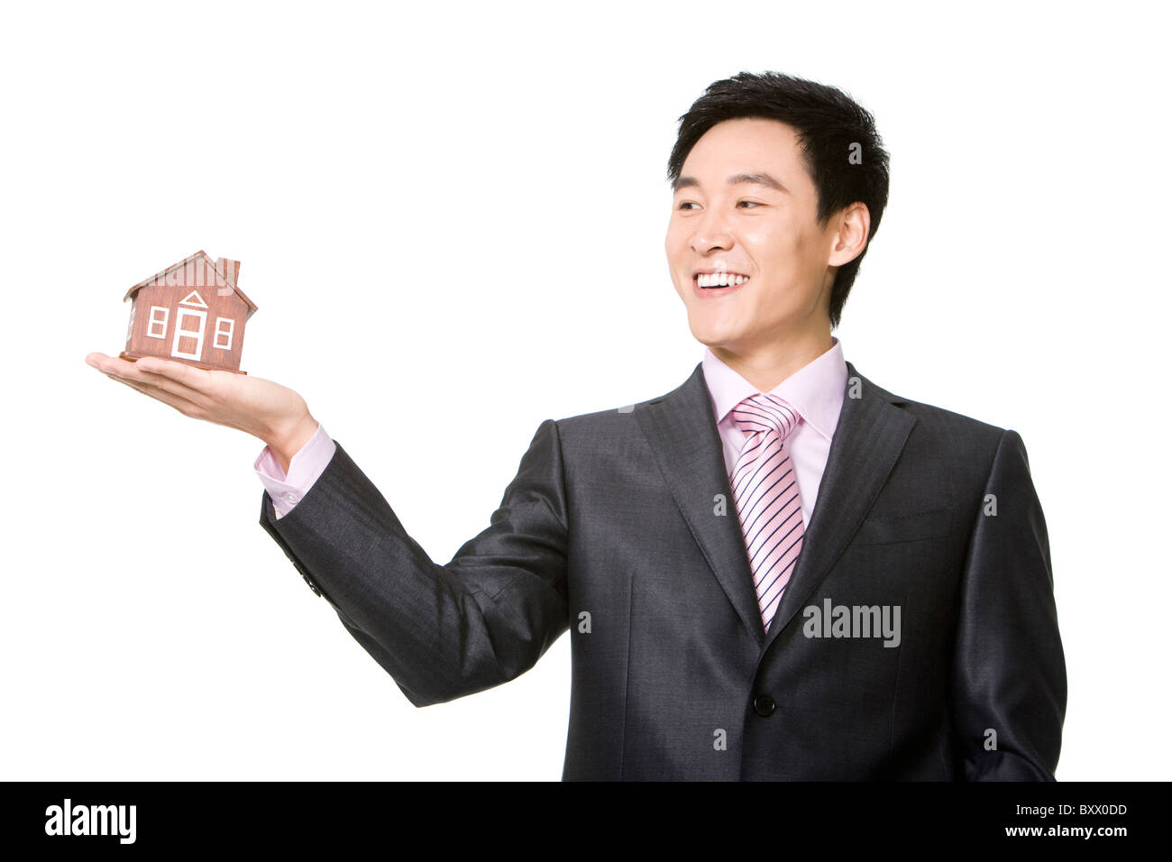 Businessman holding a small wooden model home Stock Photo - Alamy
