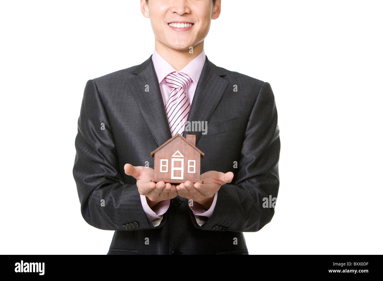 Businessman holding a small wooden model home Stock Photo - Alamy