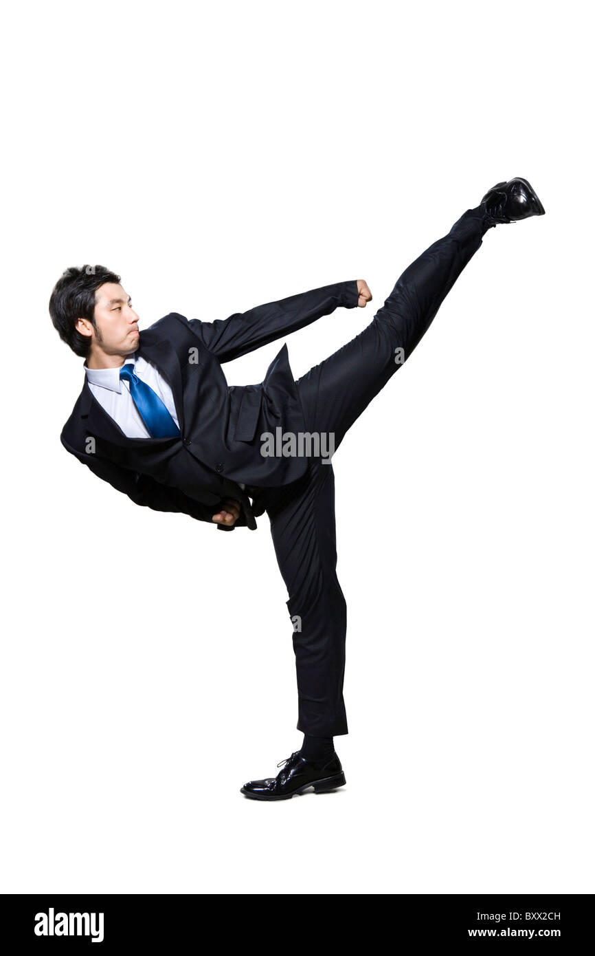 Businessman doing martial arts kick Stock Photo Alamy