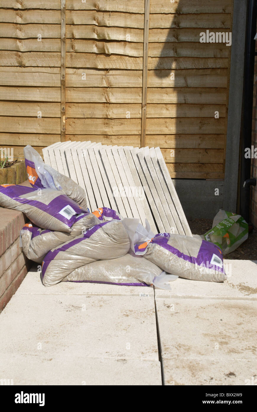 Bags of concrete mix on paving slabs Stock Photo Alamy