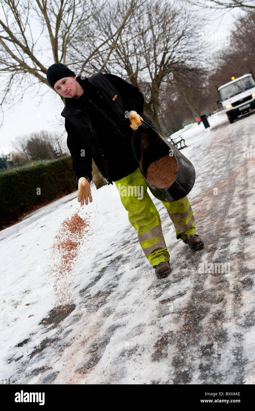 Local authority council workers spreading grit and salt by hand on icy ...