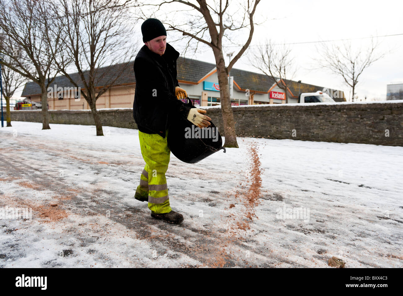 Local authority council workers spreading grit and salt by hand on icy ...