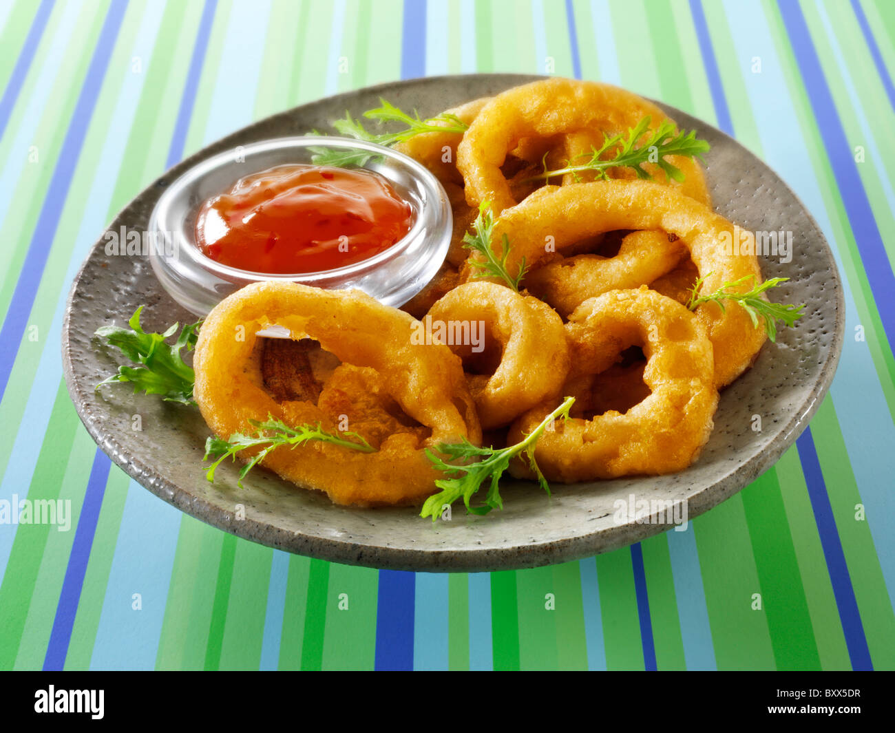 Deep Fried battered onion rings with a chilli sauce & salad Stock Photo