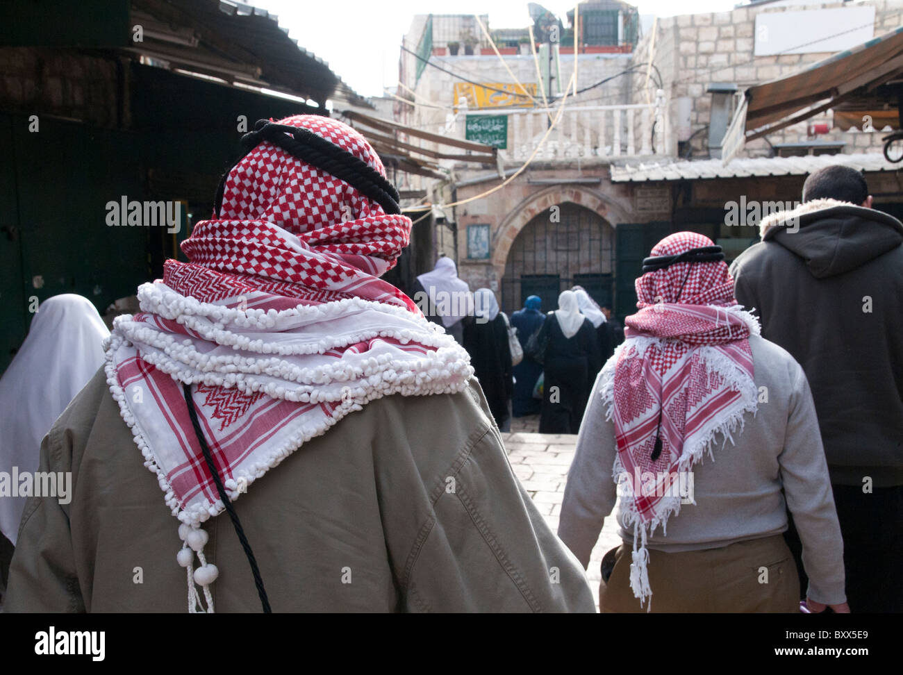 Close up of Palestinian men with keffiyeh walking in the street
