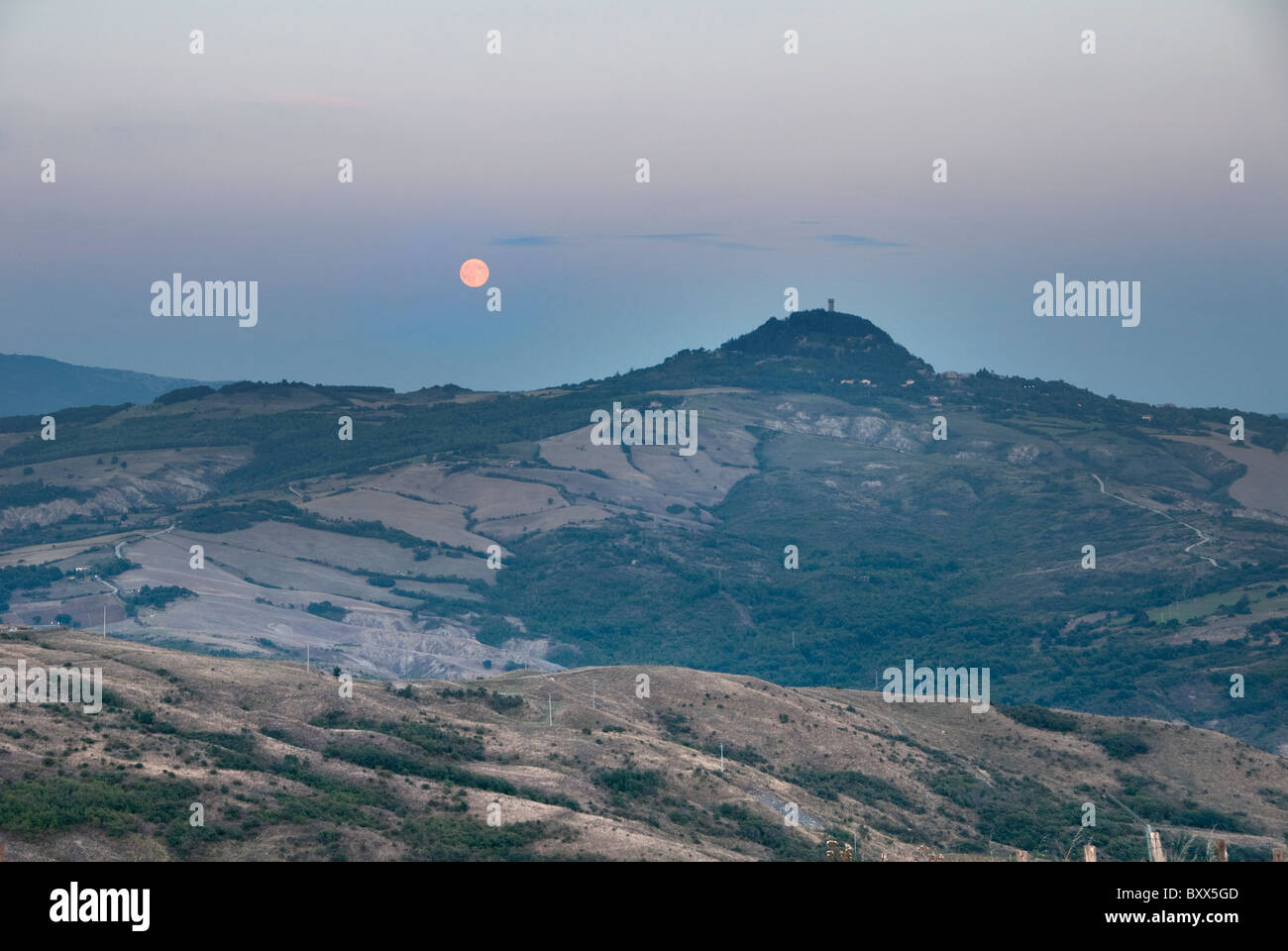 The town of Radicofani with moon rising in the Amiata area of Tuscany Stock Photo