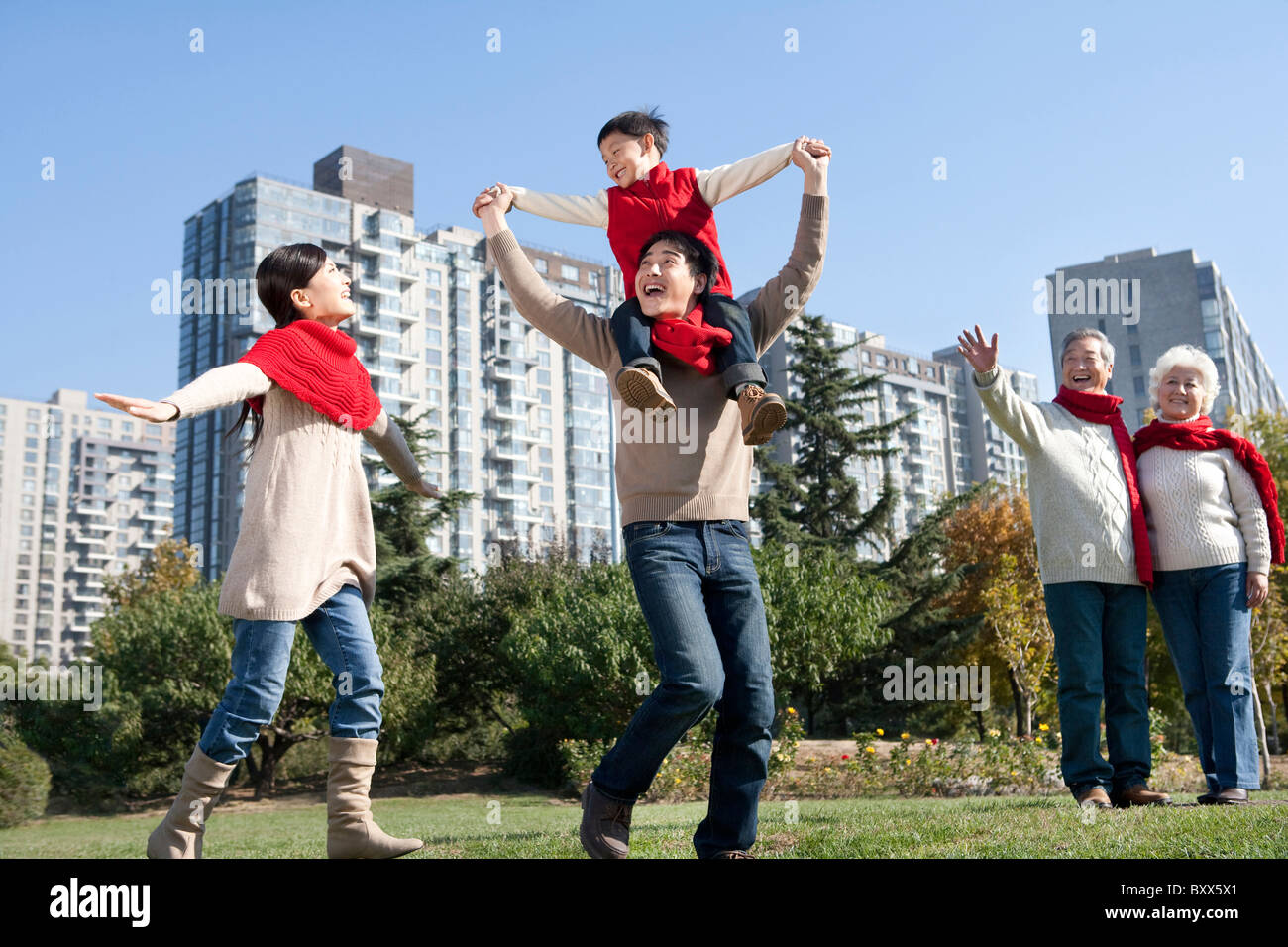 Three Generation Family Enjoying a Park in Autumn Stock Photo