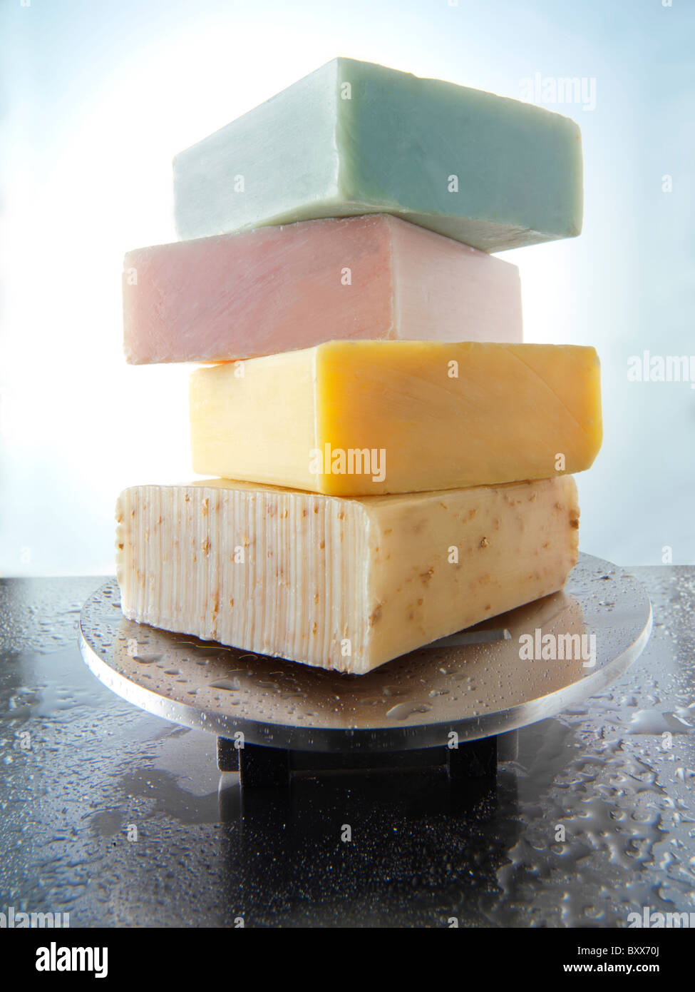 4 bars of scented hand made soap piled on an aluminium soap dish with