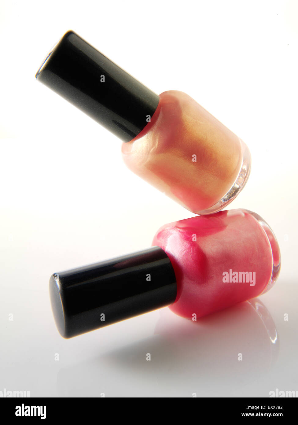 2 Nail varnish bottles balanced on each other in a fun way Stock Photo