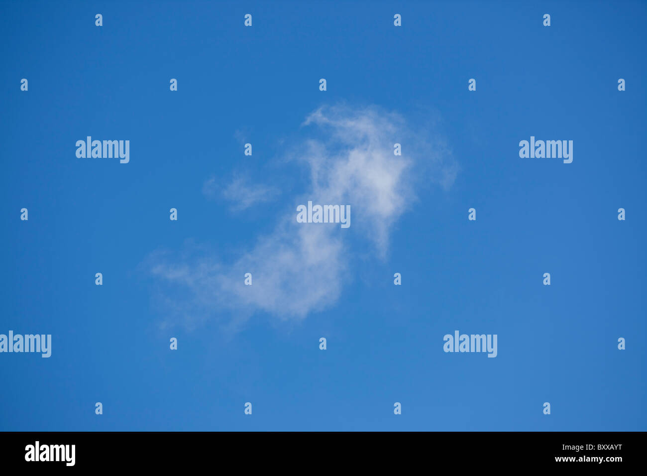 Single cirrus cloud isolated in a clear blue sky, indicating fine weather Stock Photo