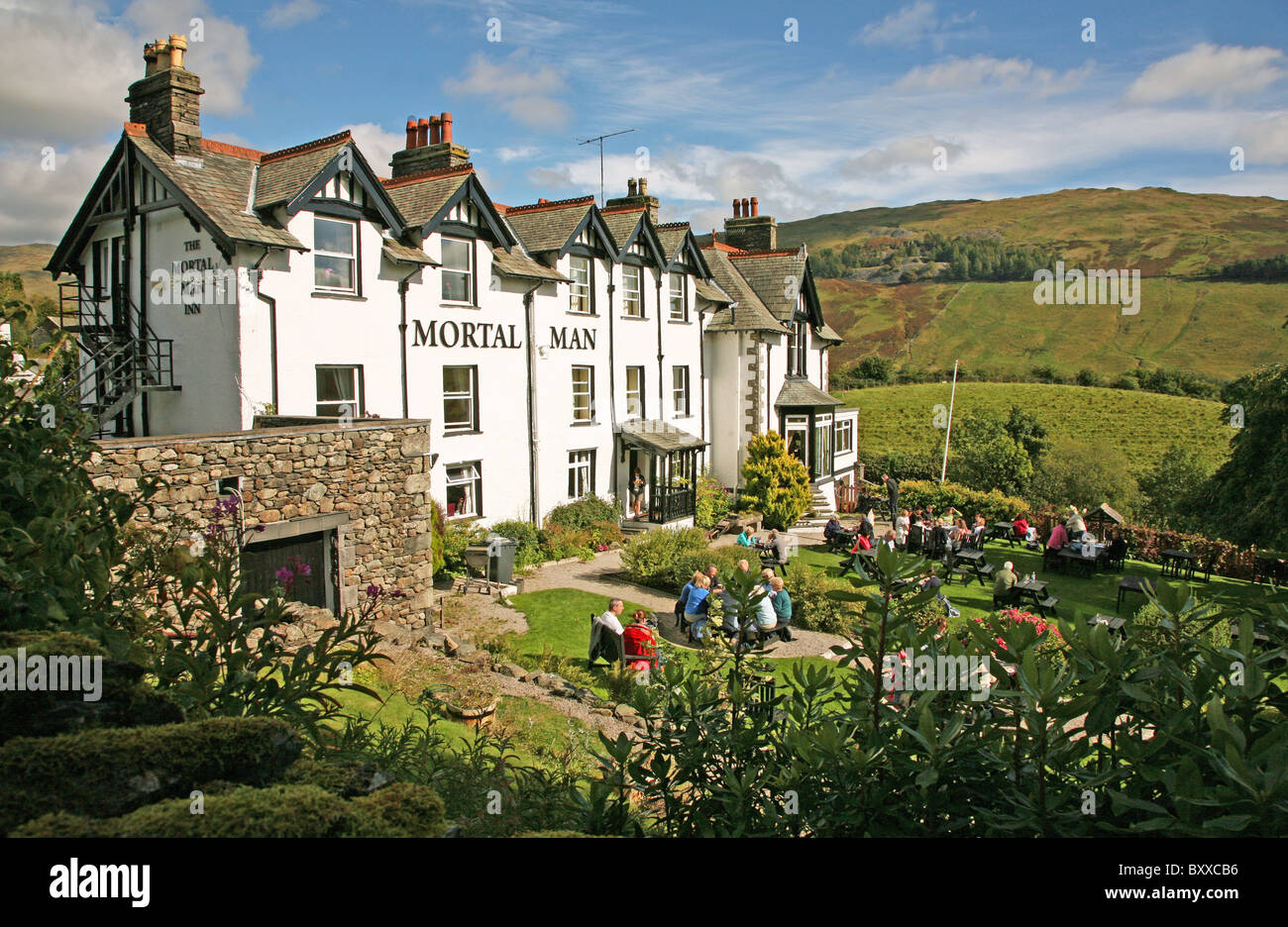 The Mortal Man pub, inn or public house, with people eating and drinking outside at Troutbeck in the English Lake District Cumbria England UK Stock Photo