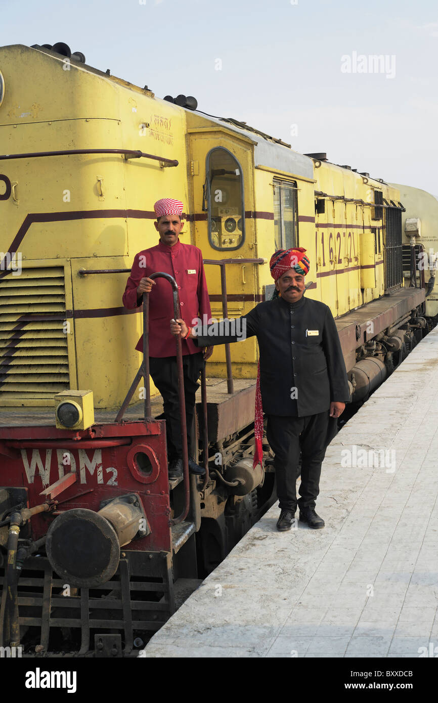 Staff members for the Palace on Wheels train posing with the train, Udaipur, India Stock Photo