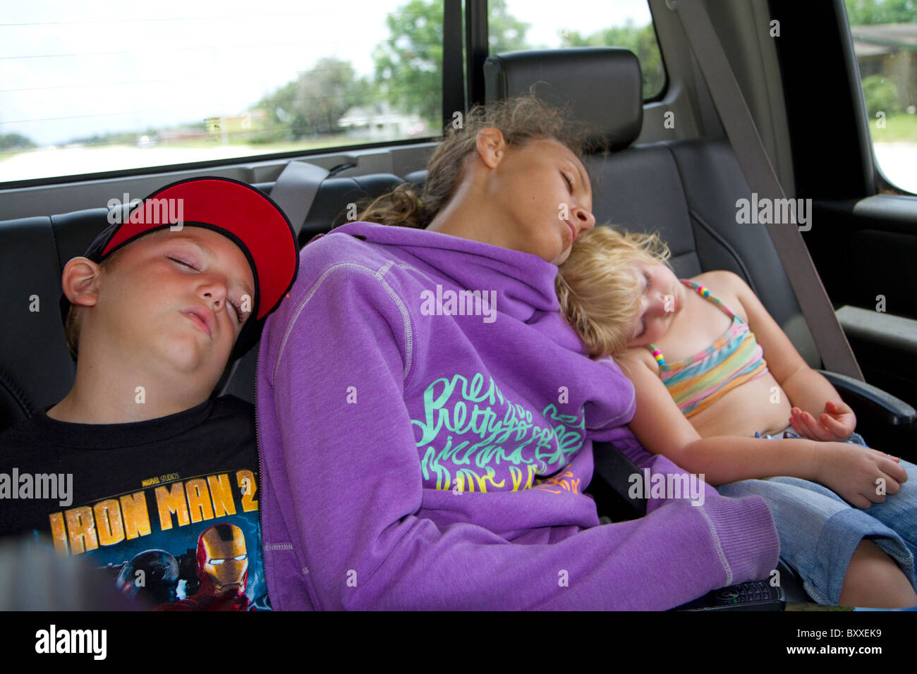 Children asleep in the backseat of a truck after a long day of fishing in Florida, USA. Stock Photo