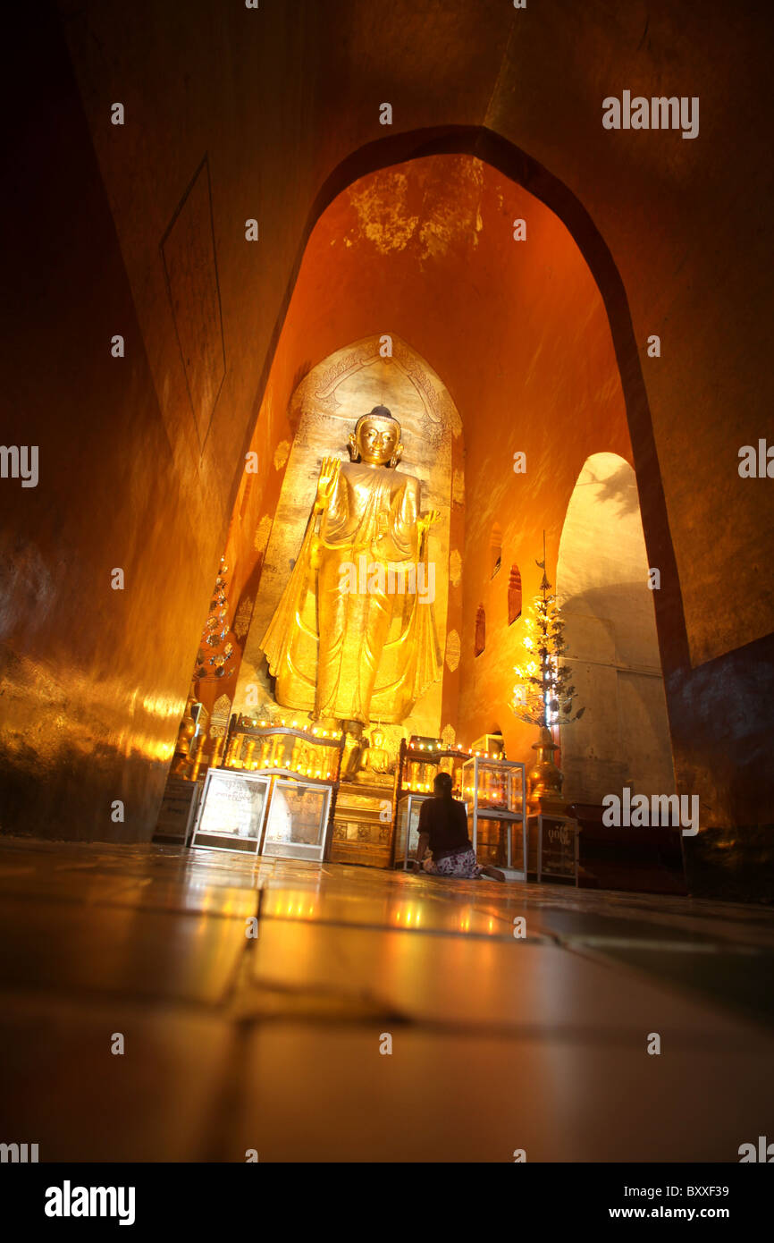 A giant golden Buddha Statue at an interior shrine in Ananda or Anandar Buddhist Temple in Bagan, Myanmar. (Burma) Stock Photo