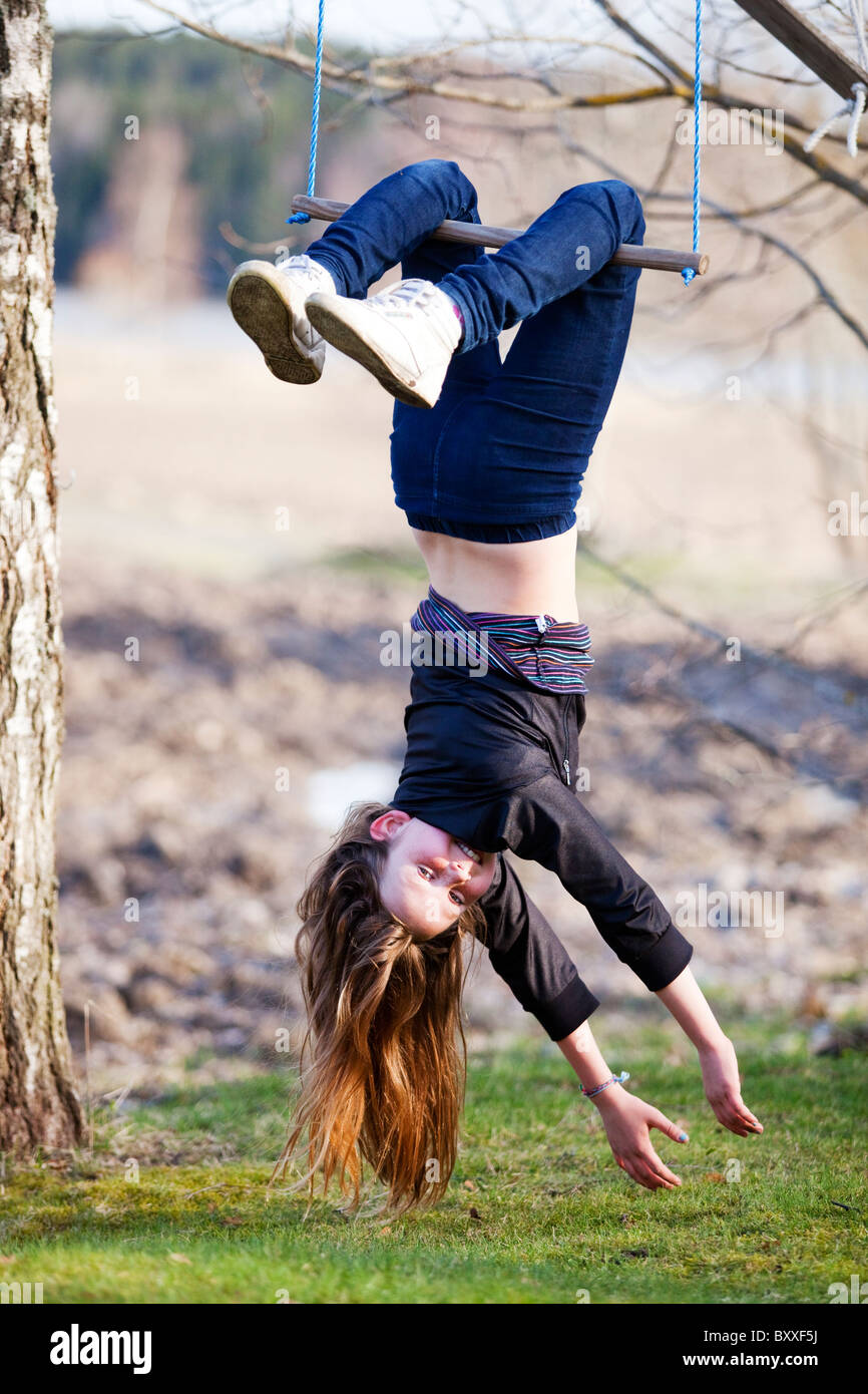 Girl hanging upside down.Haneberg,Sweden Stock Photo