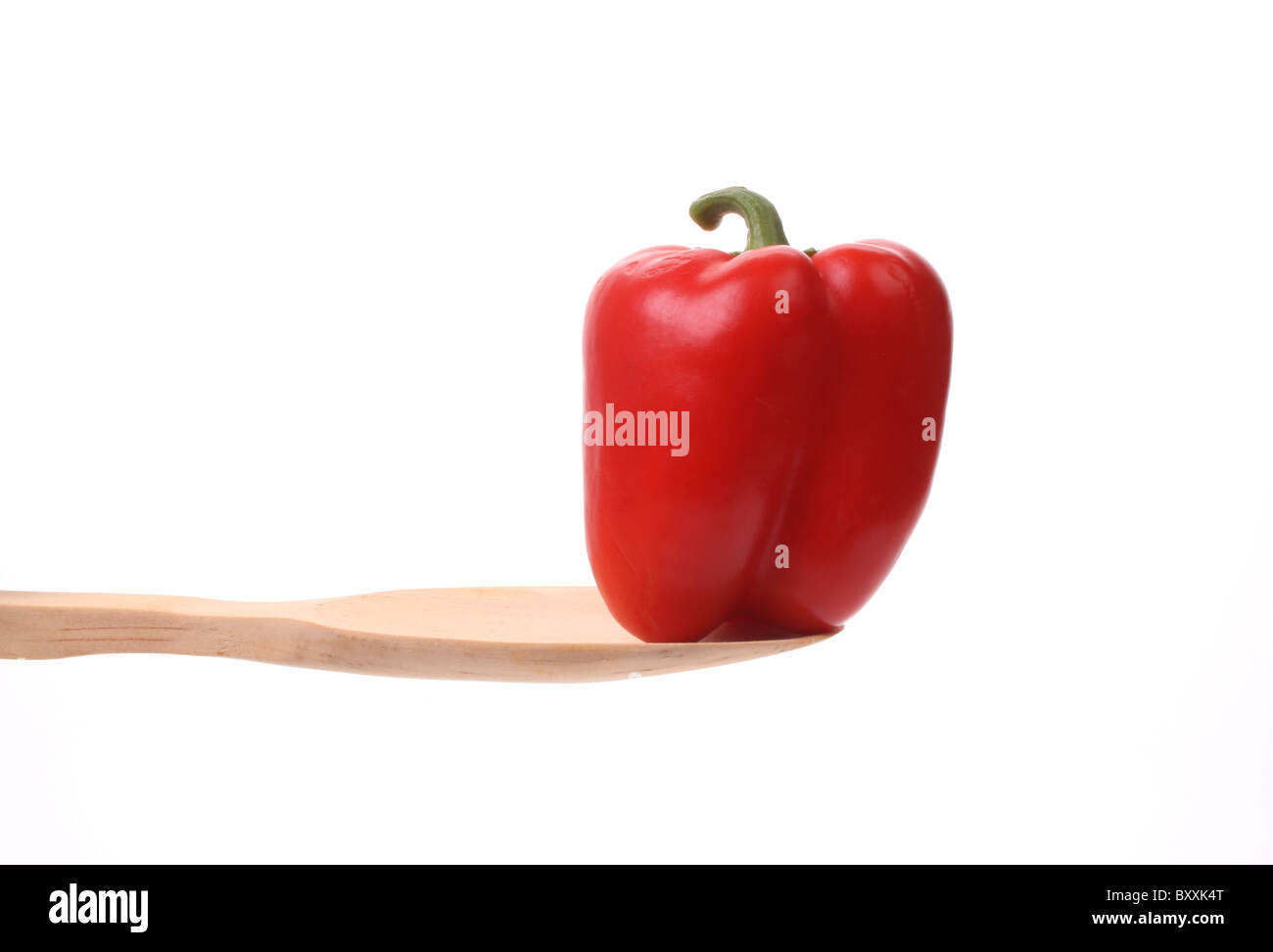 Red bell pepper on a wooden spoon against a white background Stock ...