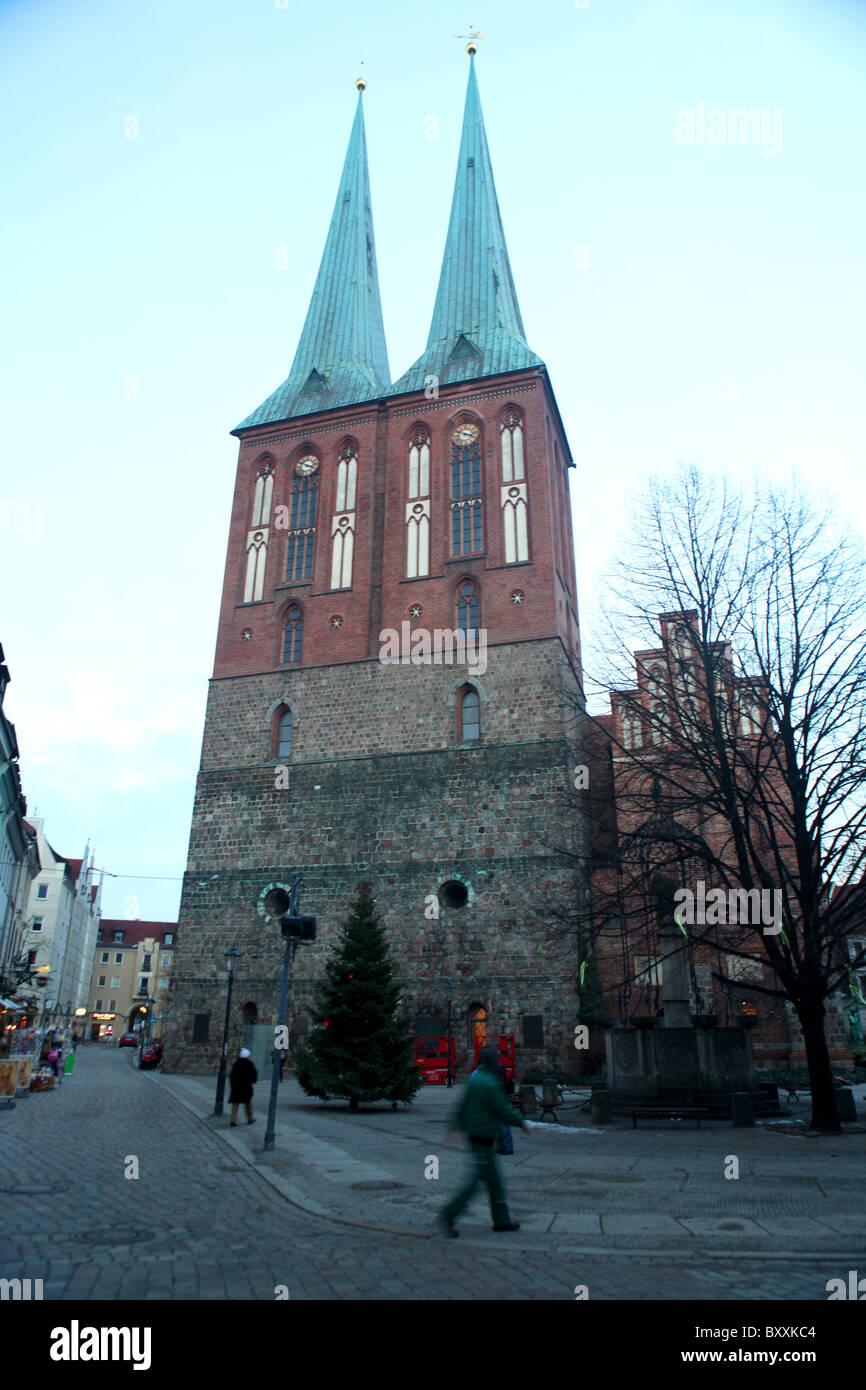 The twin spired church of St Nicholas or Nikolaikirche in Nikolaikircheplatz at dusk in Berlin, Germany. Stock Photo