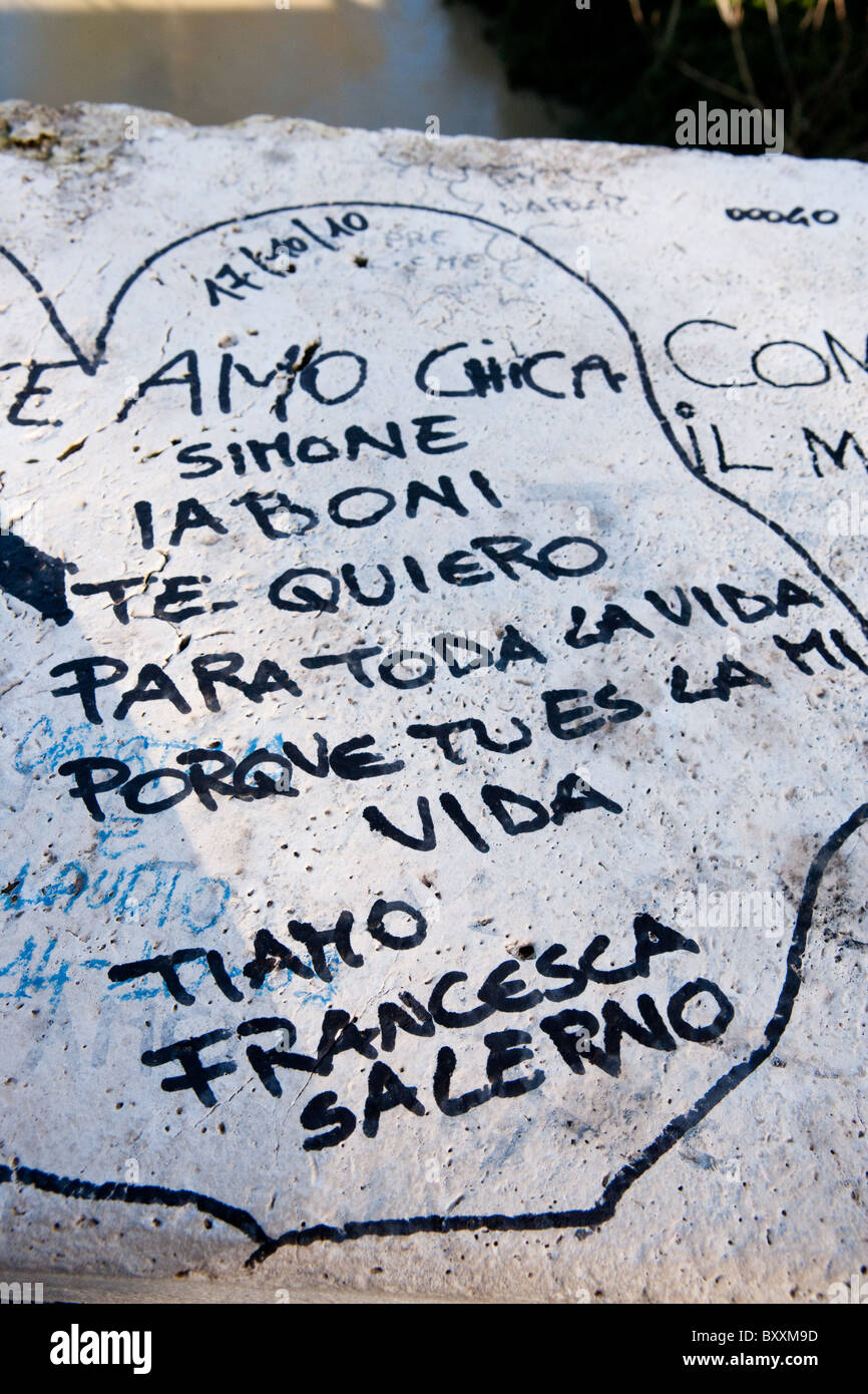 love graffiti written painted on the milvio bridge Tiber river wall marble Rome Italy pen autumn name names italian european Stock Photo