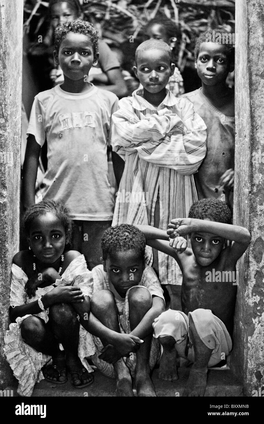 Children squeeze into the doorframe of a home at night in Djibo in northern Burkina Faso. Stock Photo
