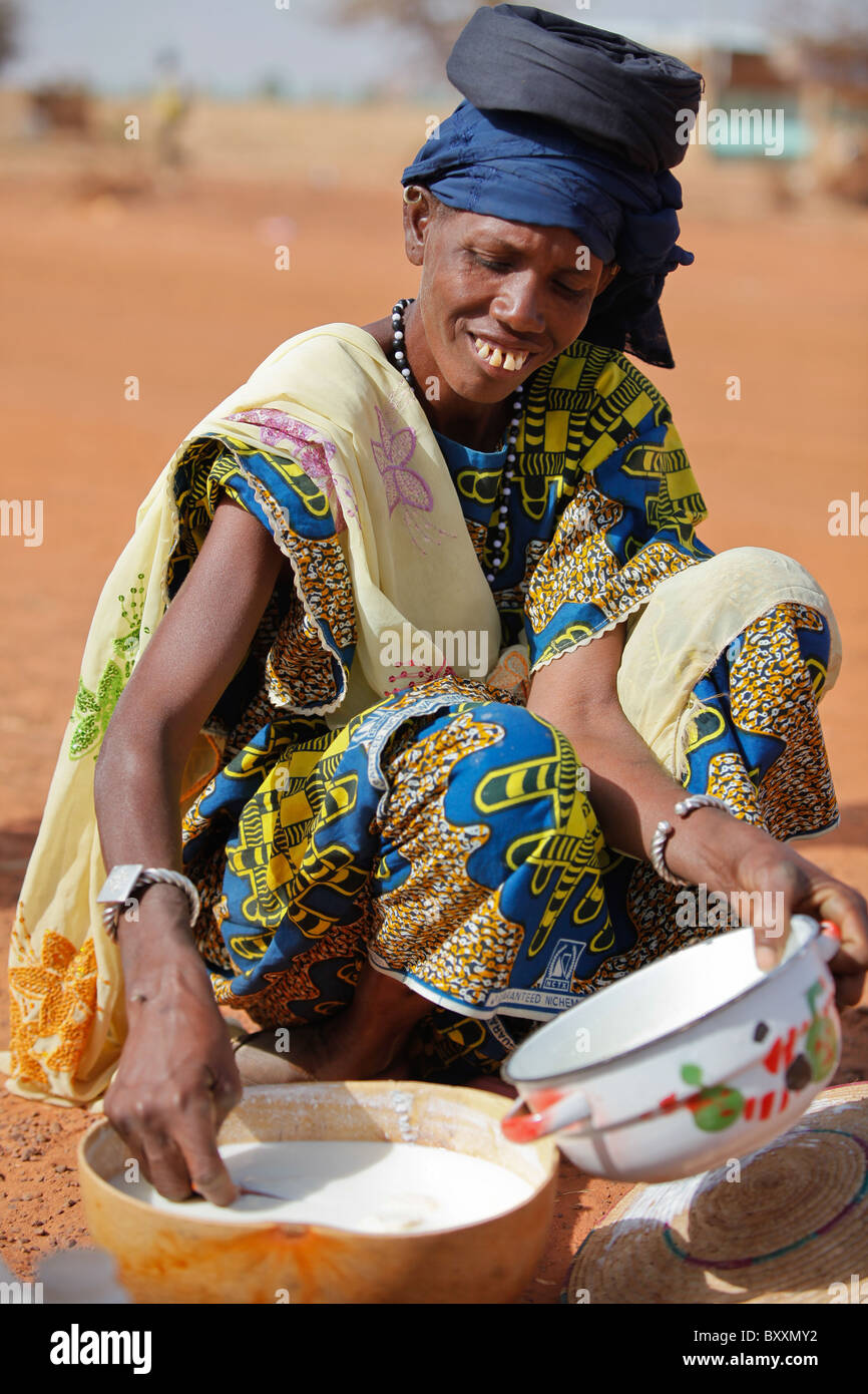 A Fulani woman carries milk in a calabash for sale in the weekly market of Djibo in northern Burkina Faso. Stock Photo
