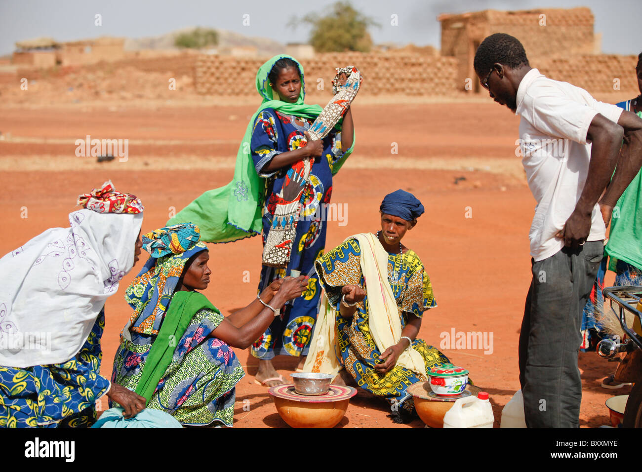 Here, women arrive in Djibo, Burkina Faso, carrying fresh milk for sale in calabashes. Stock Photo