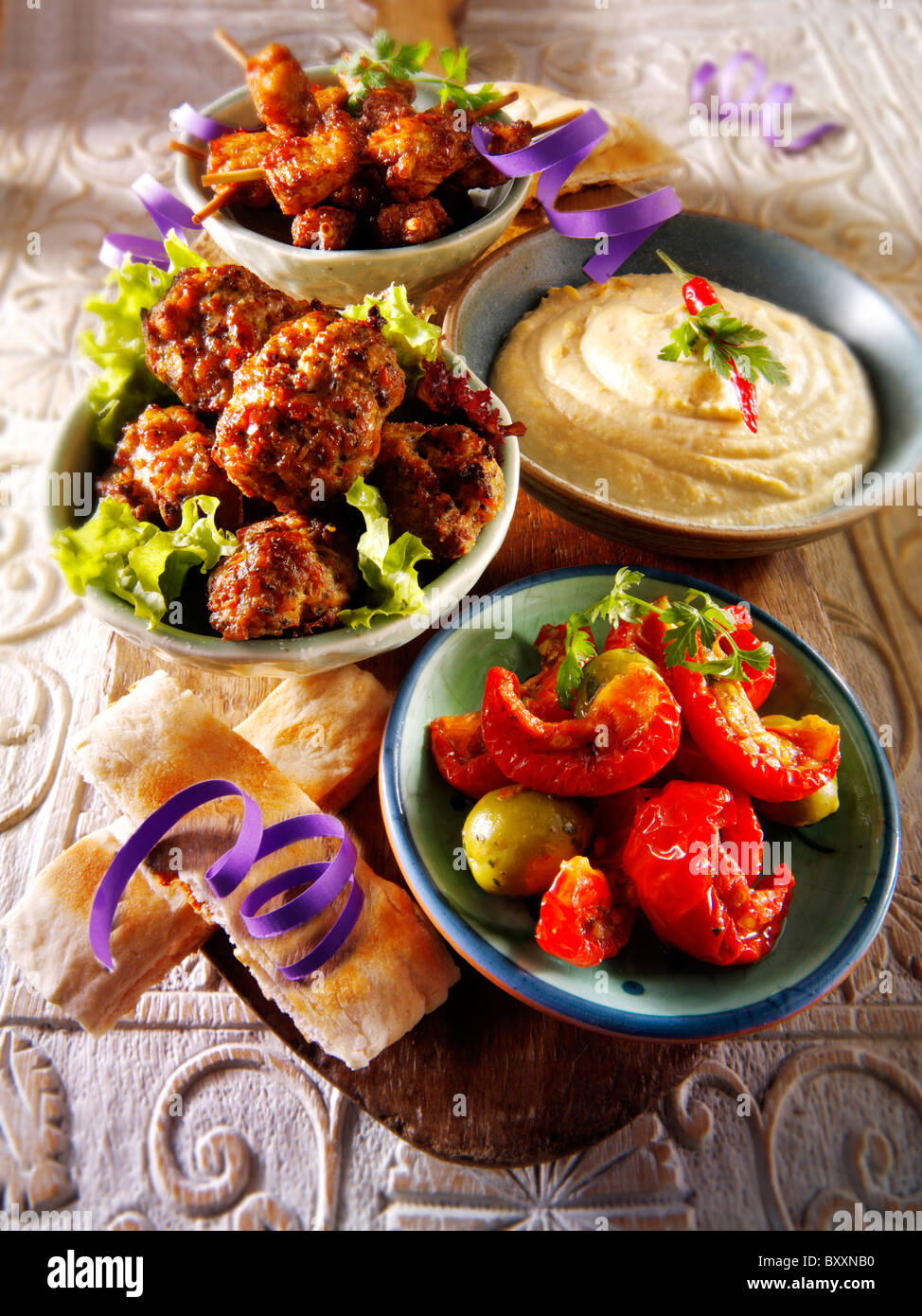 Party buffet food with Humous, meatballs, chicken satay and sundried