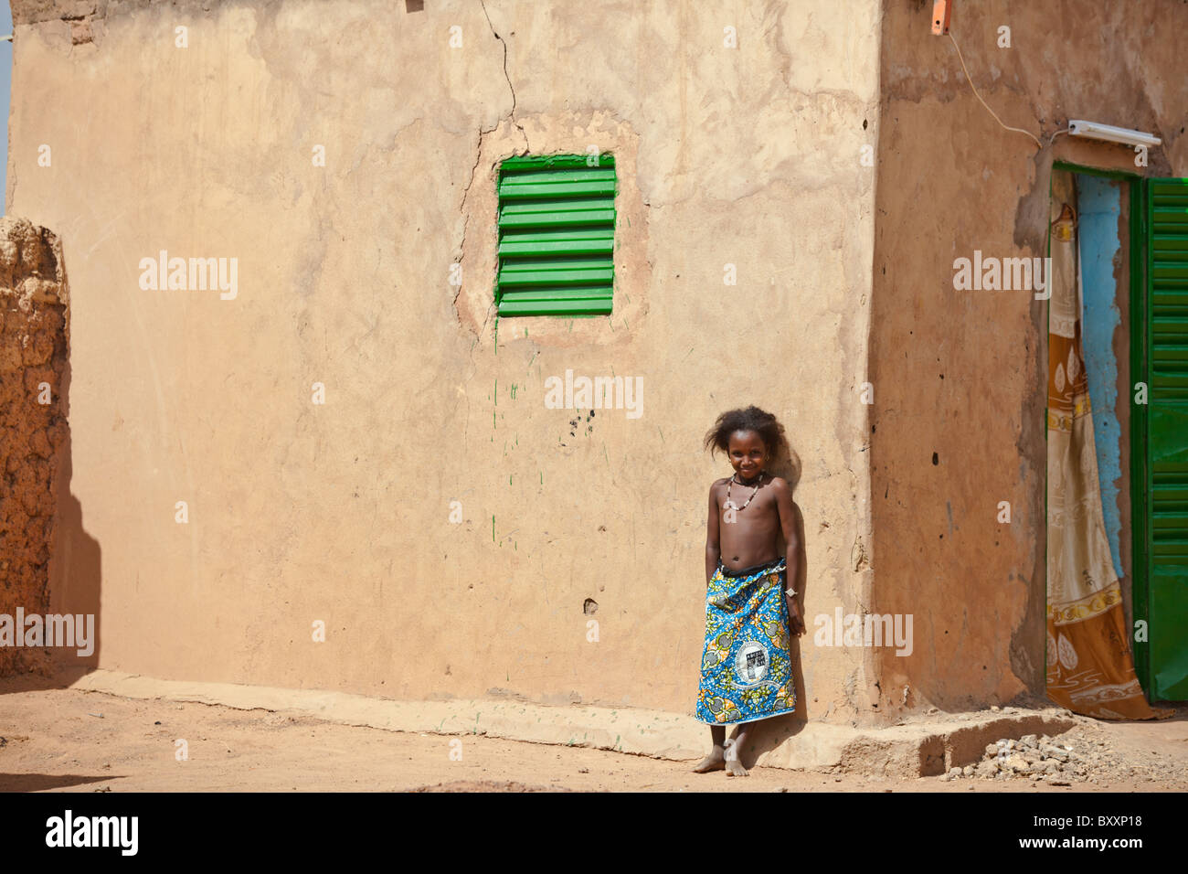 A Fulani girl stands against a mud house in the town of Djibo in northern Burkina Faso. Stock Photo