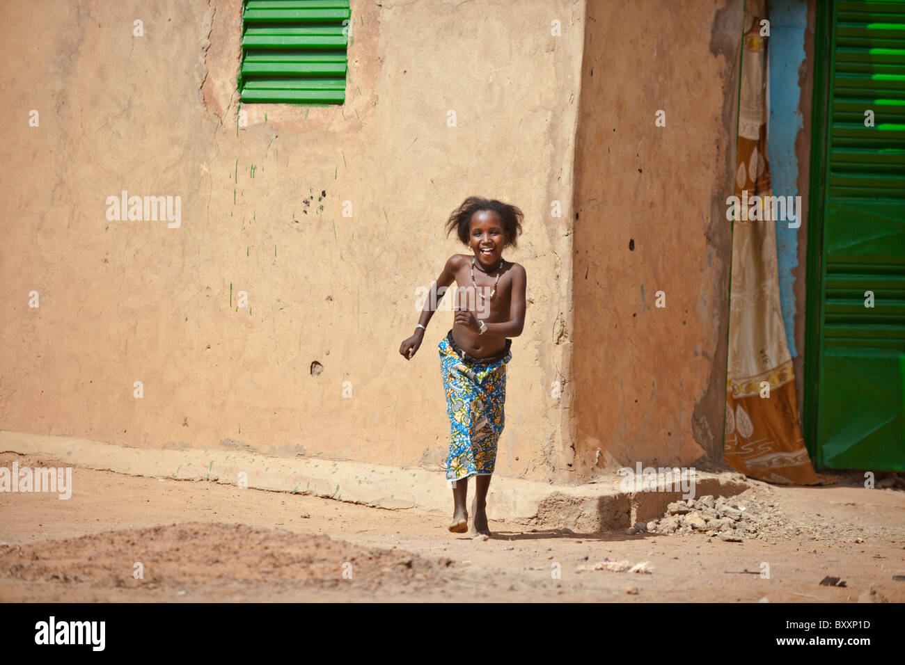 A Fulani girl stands against a mud house in the town of Djibo in northern Burkina Faso. Stock Photo