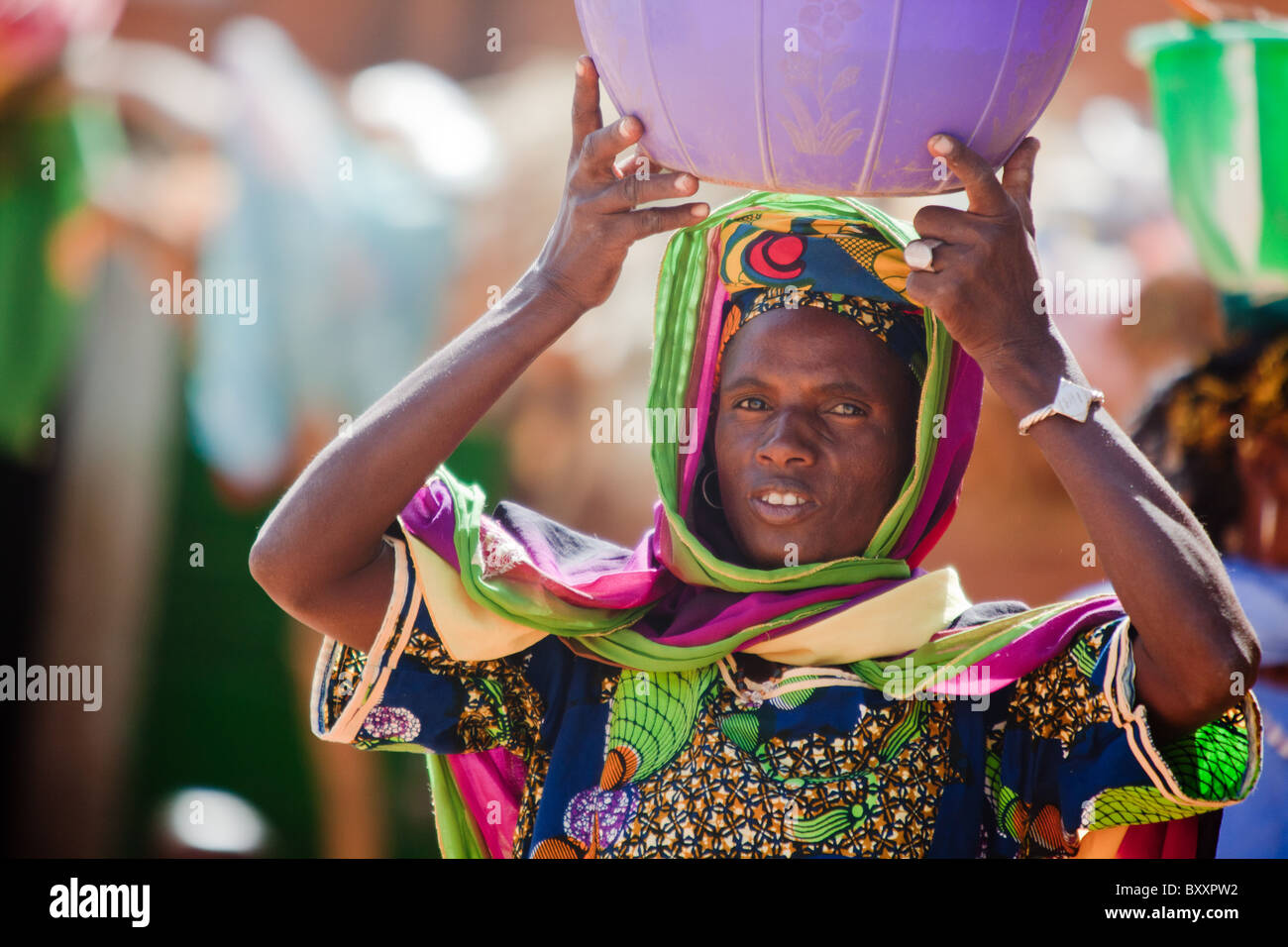 A Fulani woman brings fresh milk to sell in the weekly Djibo market in northern Burkina Faso. Stock Photo