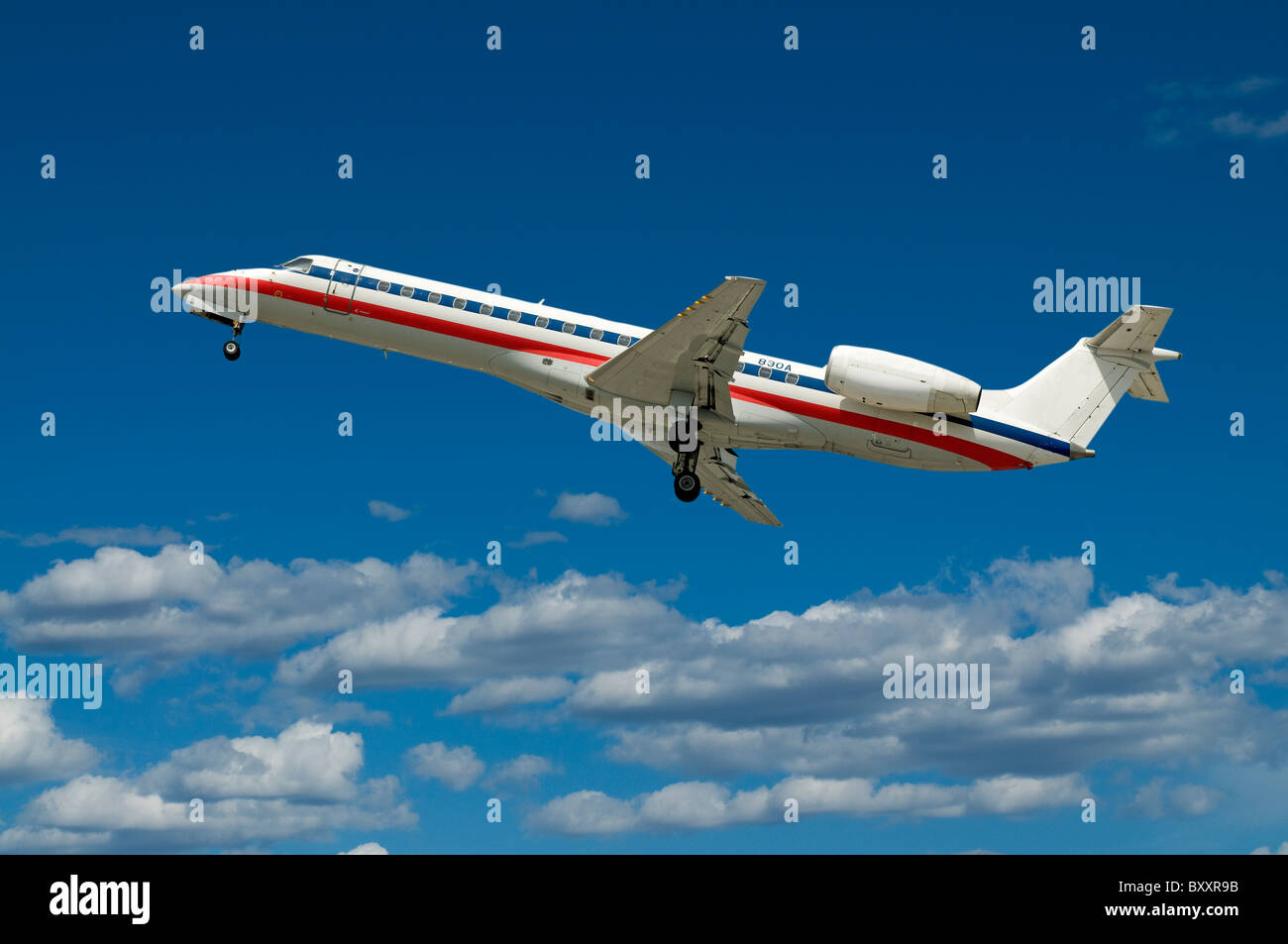 Commercial passenger jet airplane flying in blue sky with clouds Stock Photo