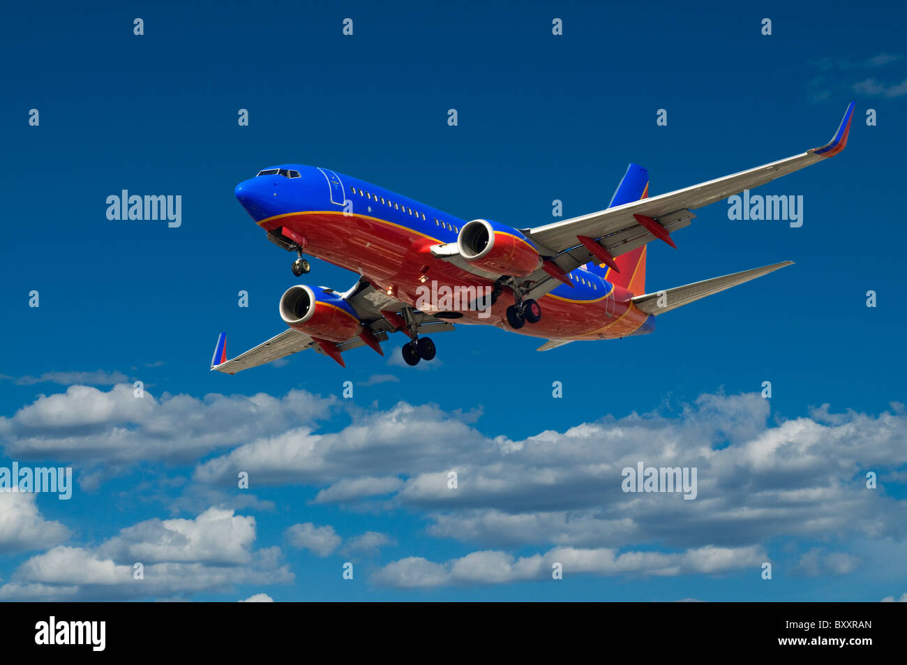 Commercial passenger jet airplane flying in blue sky with clouds Stock ...