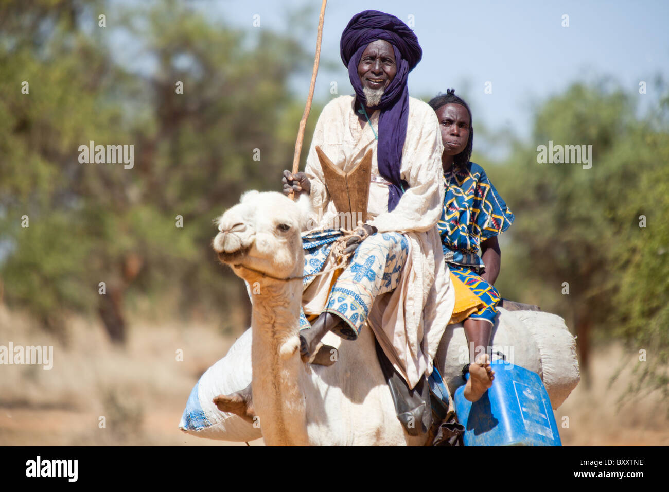 A Tuareg man and his wife come to the village market of Bourro in northern Burkina Faso by camel. Stock Photo