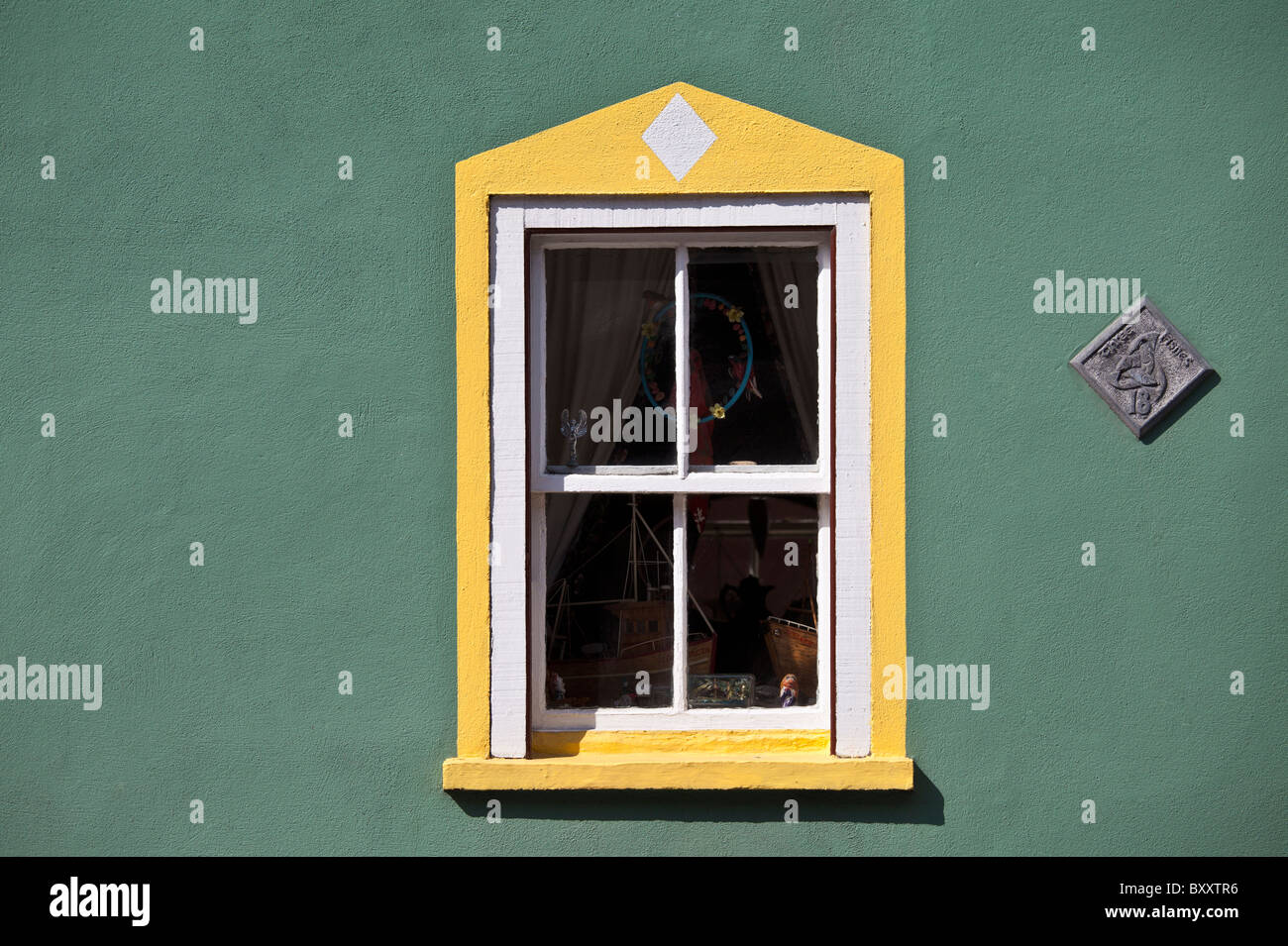 Aquamarine colour wall and yellow window border in Kinsale, County Cork, Ireland Stock Photo