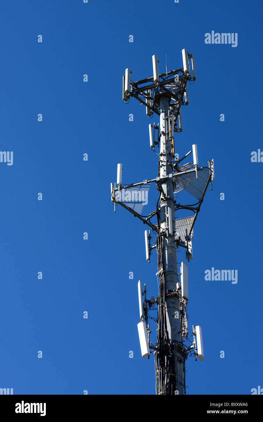 A cell tower backdropped by a blue sky Stock Photo - Alamy