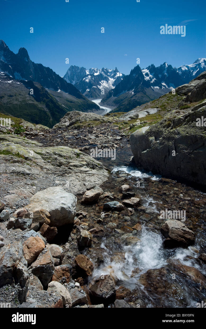 A river leads from Lac Blanc, opposite the peaks of Aiguille Verte and Mont Blanc, French Alps. Stock Photo