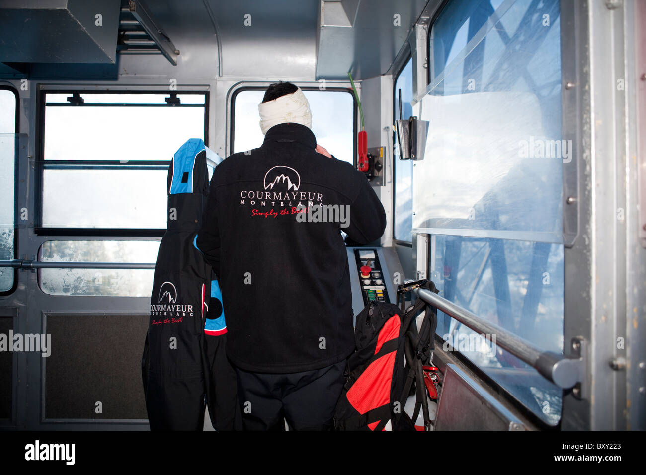 Cable car driver inside the cabin going down towards Entreves, Valle d'Aosta, Italy Stock Photo