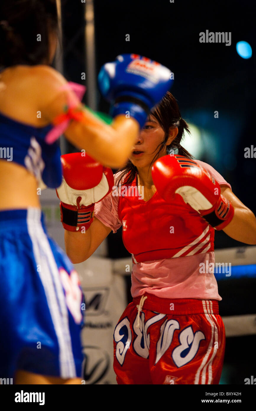 Two female muay thai kickboxers stand ready with gloves up at amateur outdoor ladies' kickboxing event Stock Photo