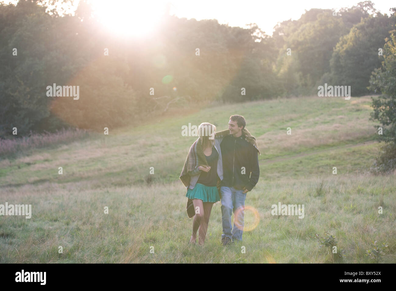 A young couple walking in the countryside in the evening sun Stock Photo
