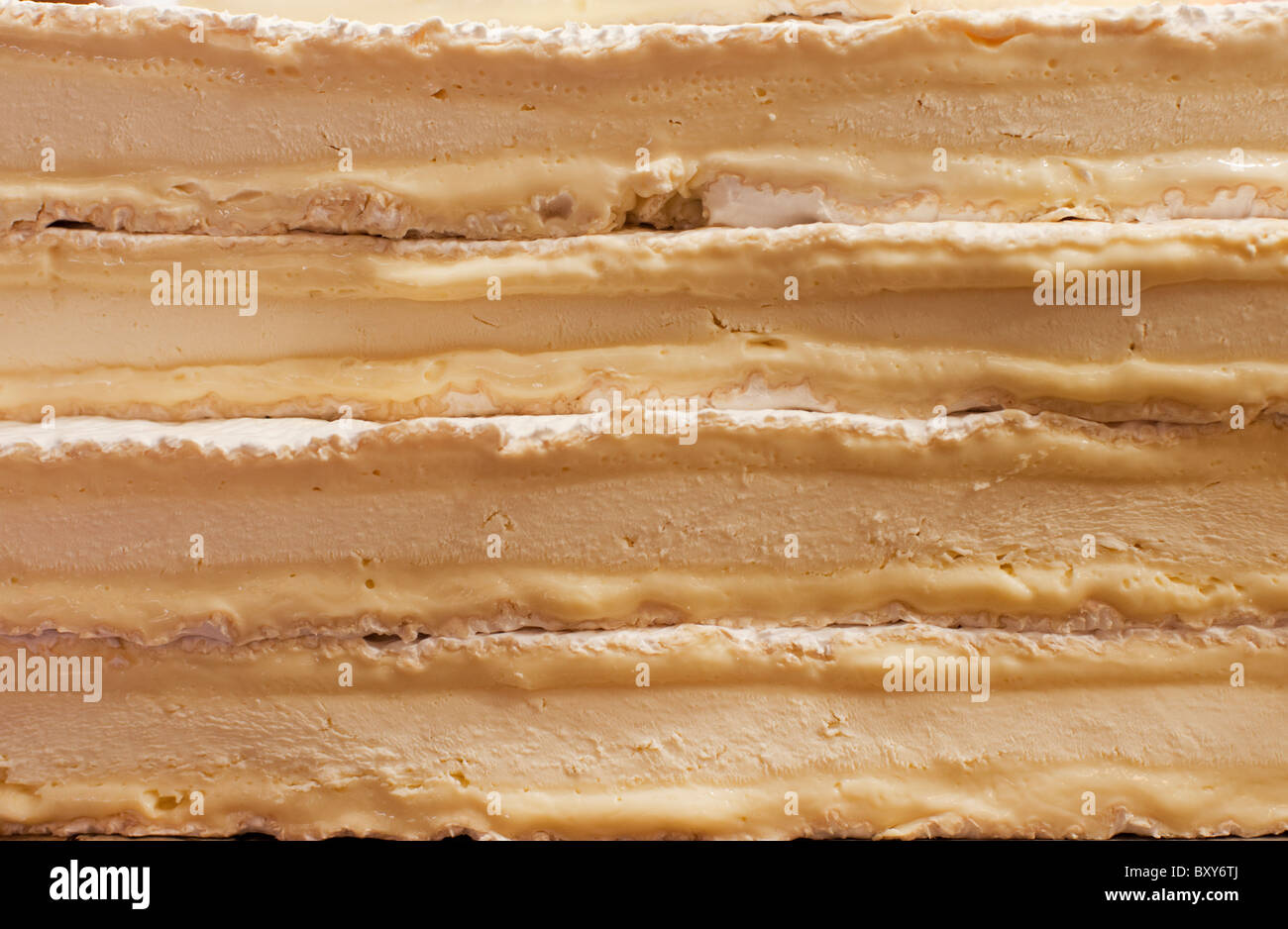 Stacks of ripening Brie cheese ooze in layers at a cheese shop Stock