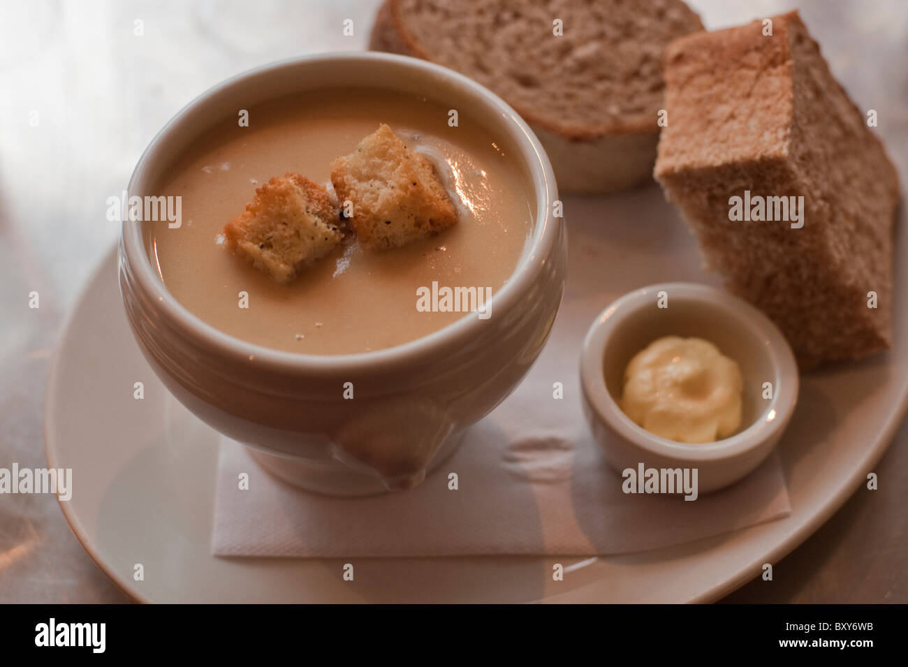 Stilton and celeriac soup served with thick slices of brown bread. Stock Photo