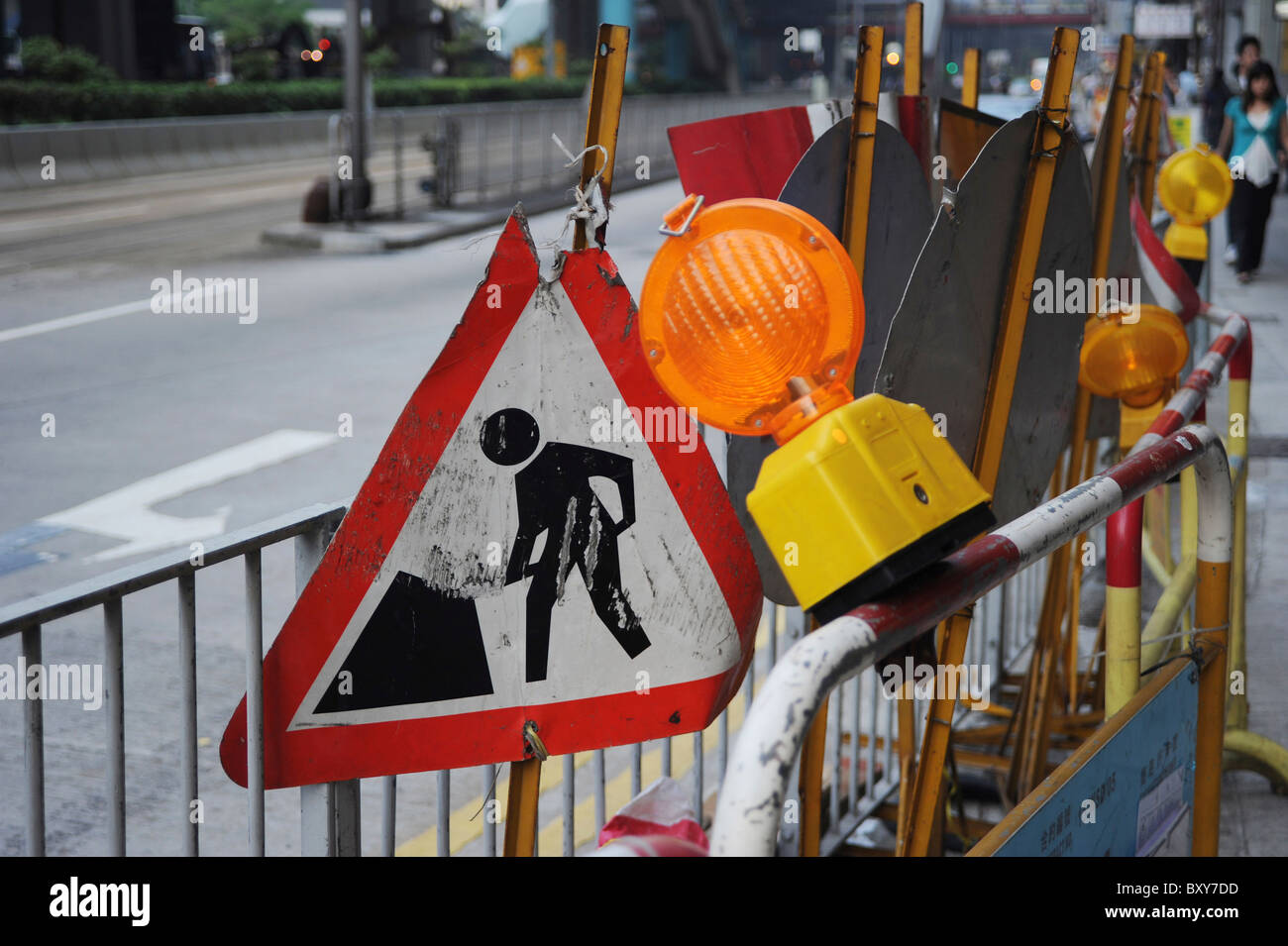Men at Work Sign and Road Work Signage in a Hong Kong Street Stock Photo