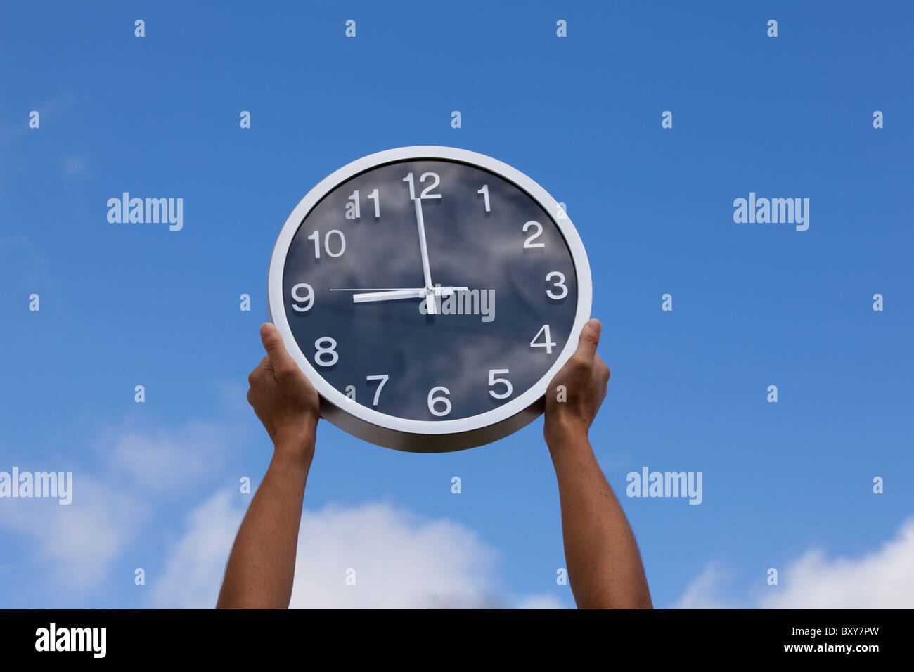 hands holding a wall clock up to the sky Stock Photo Alamy