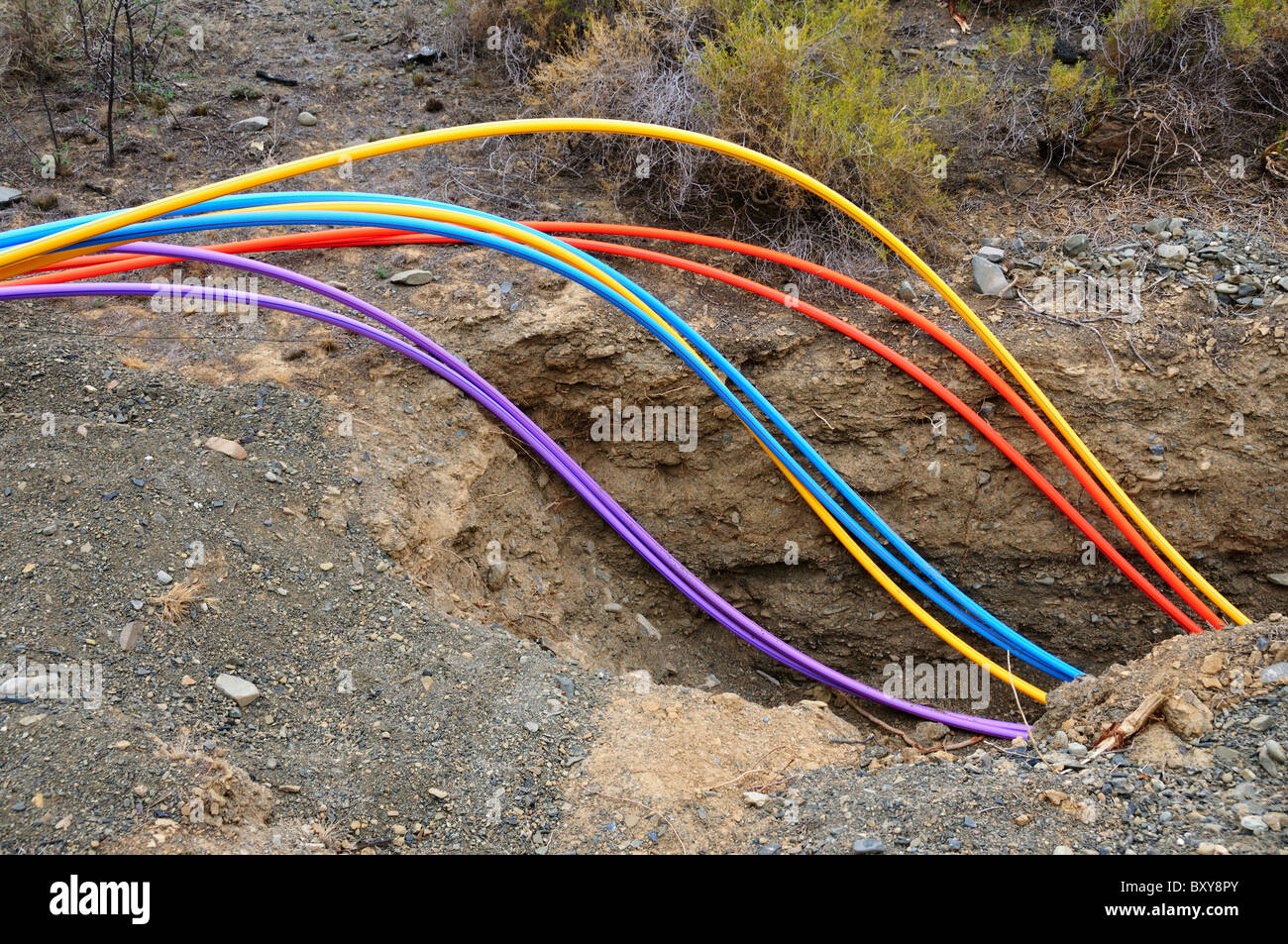 Colorful fiber optical cables are buried in a ditch. South Africa. Stock Photo