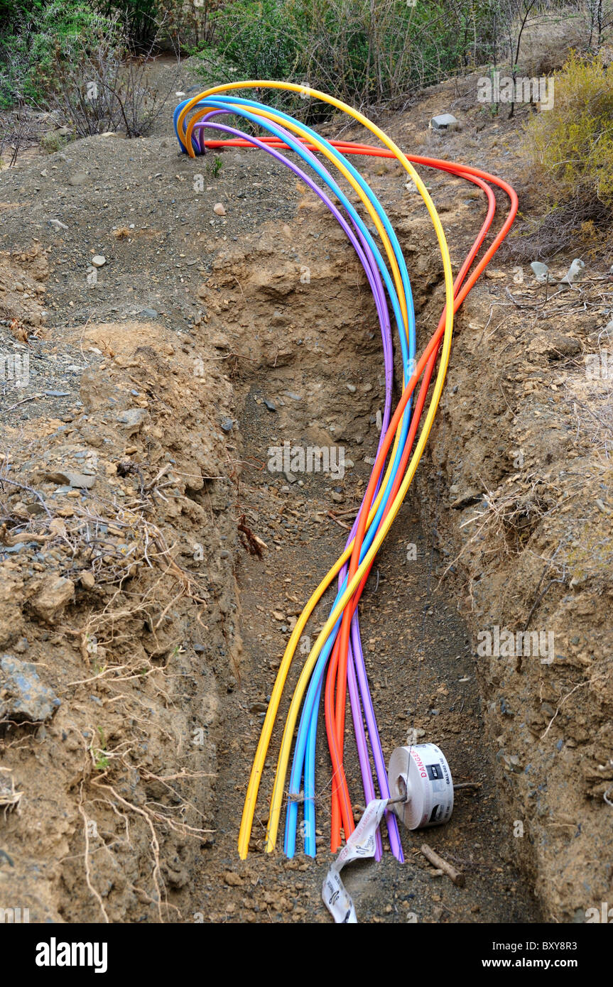 Colorful fiber optical cables are buried in a ditch. South Africa. Stock Photo