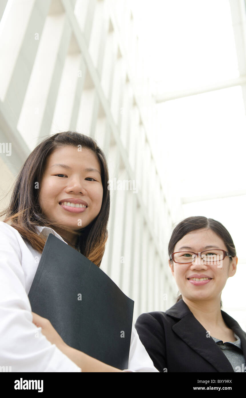 2 asian business women smiling Stock Photo - Alamy
