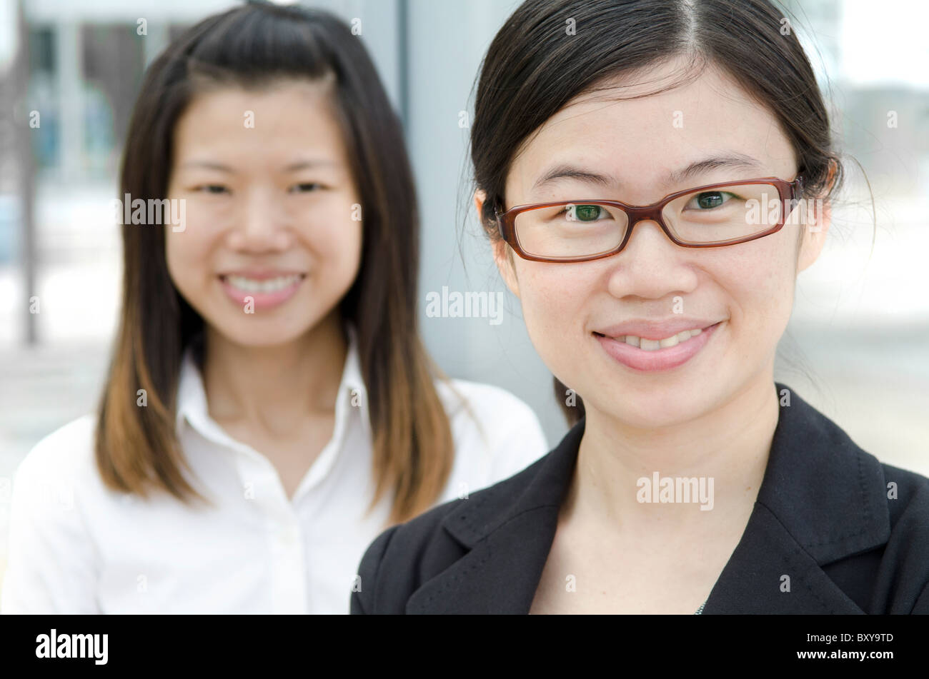 2 asian business women smiling Stock Photo - Alamy