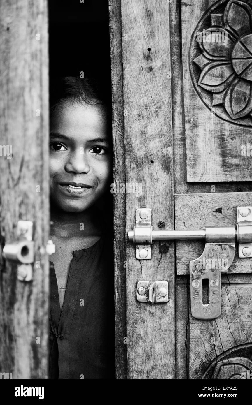 Young girl looking through door Black and White Stock Photos & Images