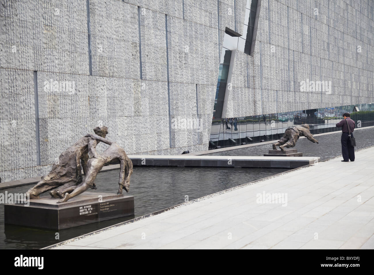 Man looking at statues at Memorial to the Nanjing Massacre, Nanjing, Jiangsu, China Stock Photo
